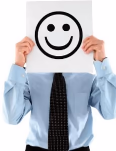 Businessman holding a smiley face over his face